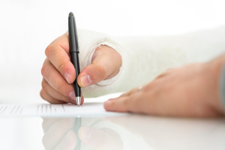 An injured person filling out paperwork