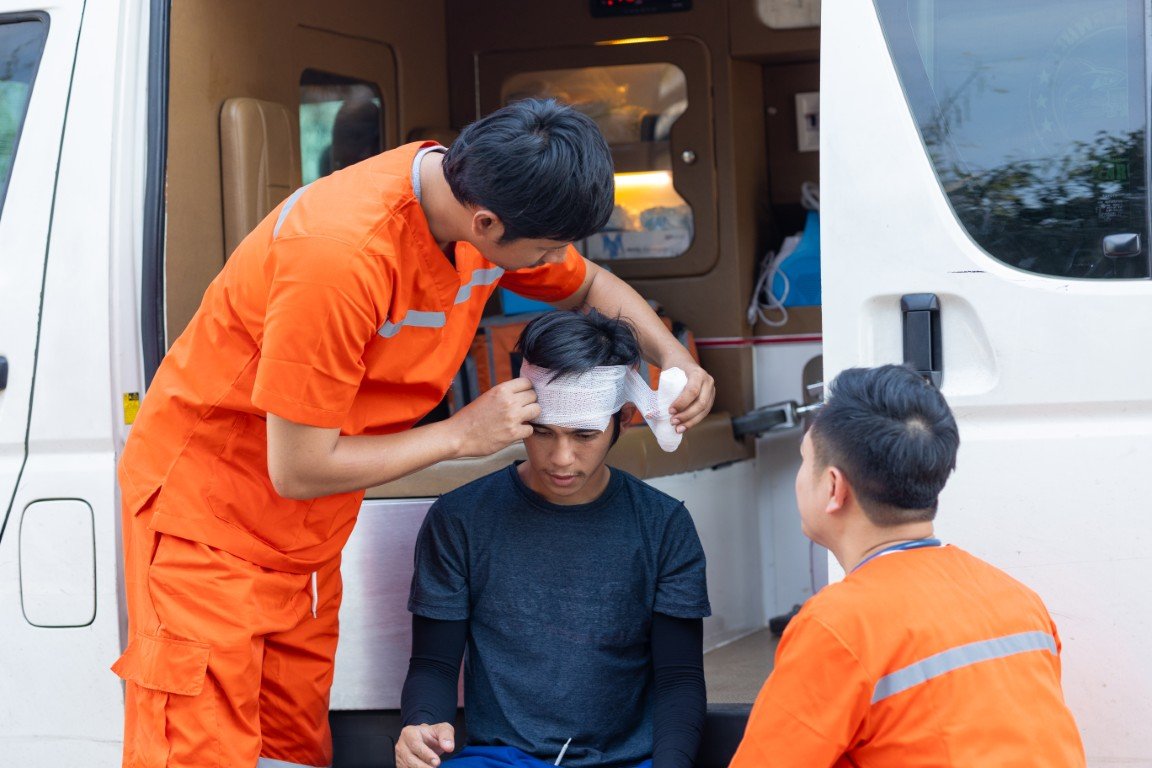 A man being treated for a head injury by emergency medical providers